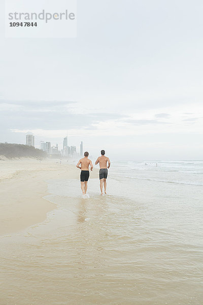 Männer laufen am Strand