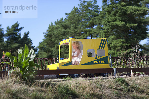 Mädchen fährt Krankenwagen Spielzeugauto