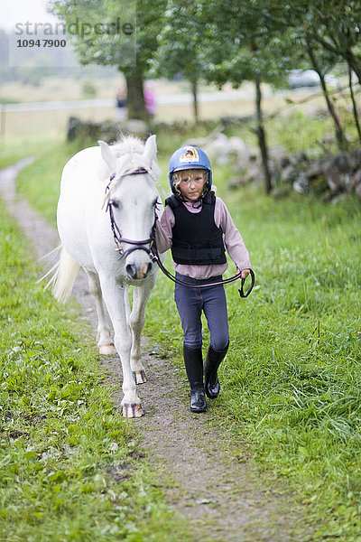 Mädchen zu Fuß mit Pferd