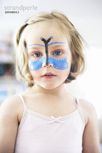 Porträt eines Mädchens mit einem auf das Gesicht gemalten Schmetterling