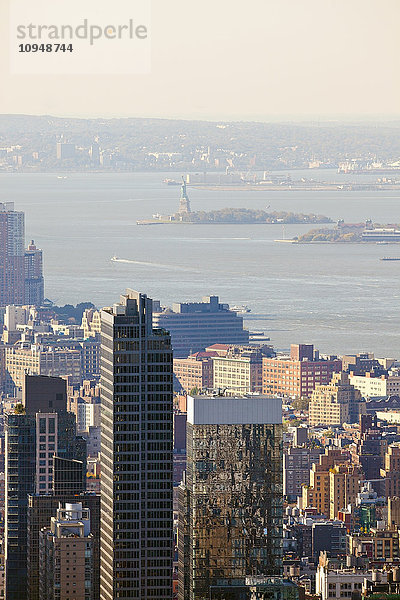 Blick auf die Wolkenkratzer von New York City mit der Freiheitsstatue im Hintergrund