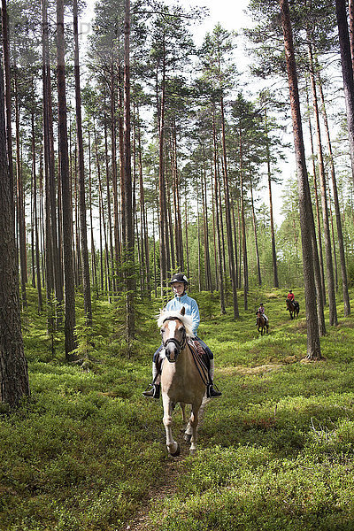 Mädchen reitet durch den Wald