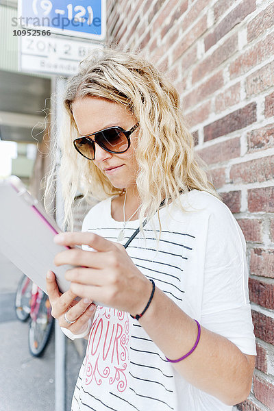 Blonde Frau mit digitalem Tablet