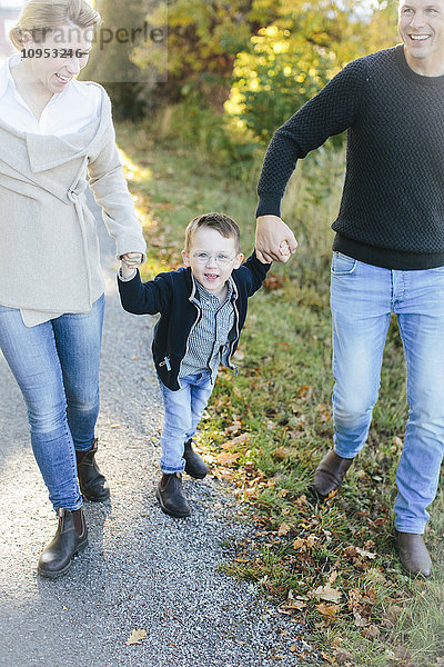Eltern gehen mit ihrem Sohn spazieren