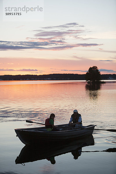 Menschen auf Boot bei Sonnenuntergang