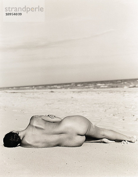 Nackte Frau am Strand liegend