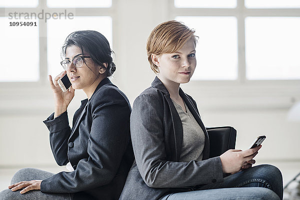 Geschäftsfrauen mit Mobiltelefonen