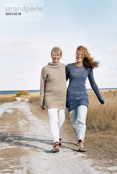 Mutter und erwachsene Tochter gehen zusammen spazieren