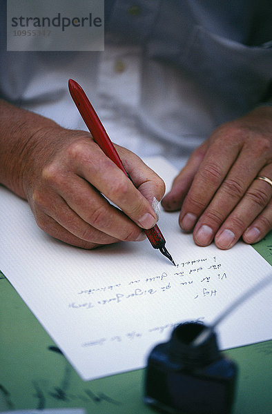 Die Hände einer Frau  die einen Brief schreibt.