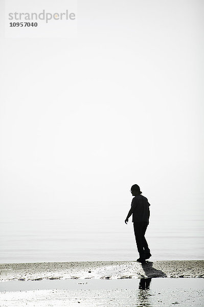 Ein Mann  der an einem Strand spazieren geht  Skane  Schweden.