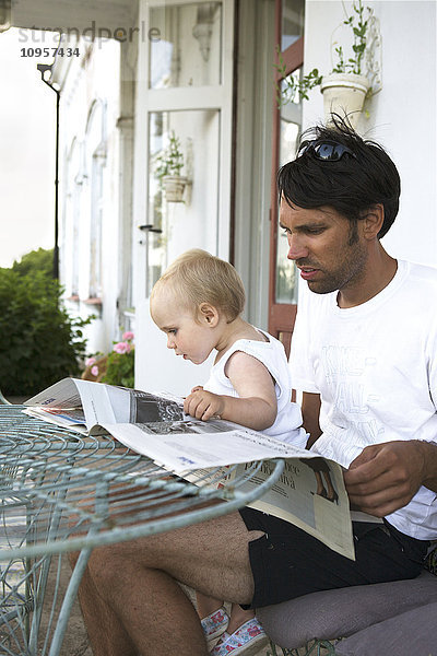 Vater und Kind lesen die Zeitung  Schweden.