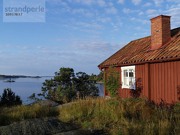 Eine rote Hütte in den Schären von Stockholm  Schweden.