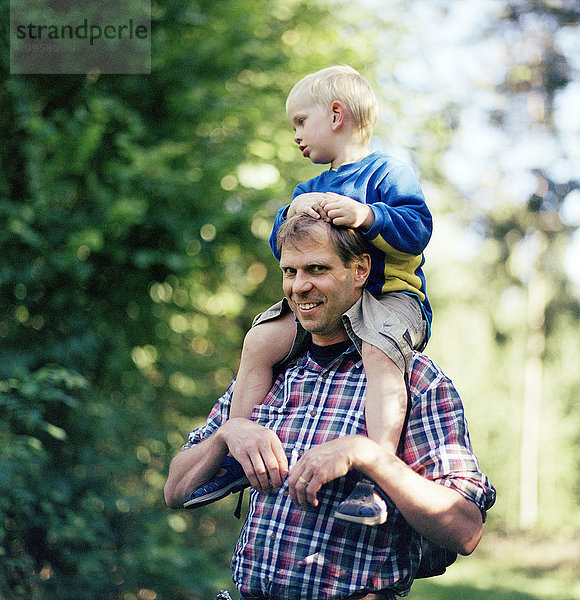 Vater geht mit seinem Sohn im Wald spazieren  Schweden.