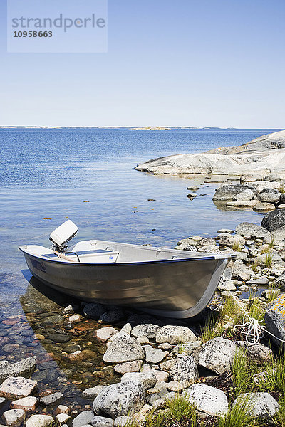 Ein Boot an einem felsigen Strand  Schweden.