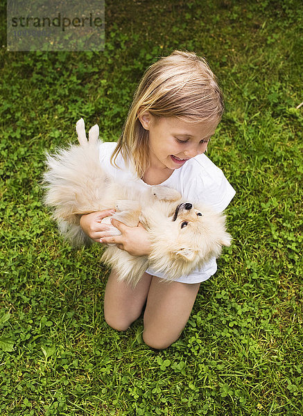 Mädchen hält einen kleinen Hund  Schweden.
