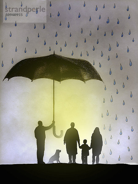 Geschäftsmann hält einen Regenschirm über einer Familie