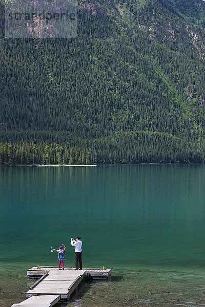 Mutter und Tochter auf einem Steg im Muncho Lake Provincial Park  British Columbia  Kanada  Sommer