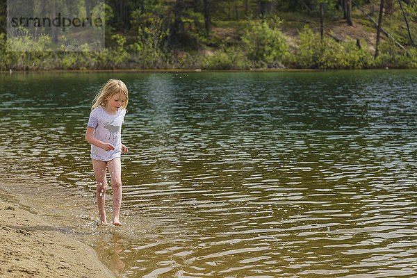 Ein junges Mädchen spielt im Wasser an einem Sandstrand  Lucky Lake  Yukon Territory  Kanada  Sommer