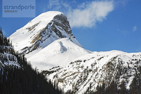 Nahaufnahme einer schneebedeckten Bergspitze mit blauem Himmel und Wolken; Banff  Alberta  Kanada'.