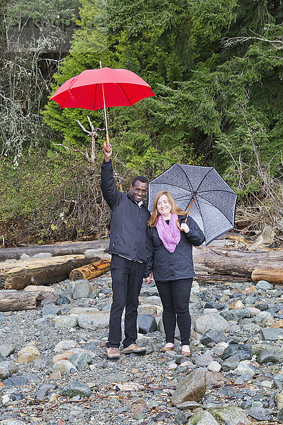 Ein Paar posiert mit Regenschirmen im Whytecliff Park  Horseshoe Bay; British Columbia  Kanada'.