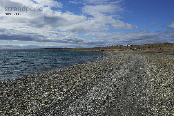 Küstenlinie entlang der Bucht von Cambridge  mit Gebäuden und Tundra in der Ferne; Cambridge Bay  Nunavut  Kanada'.