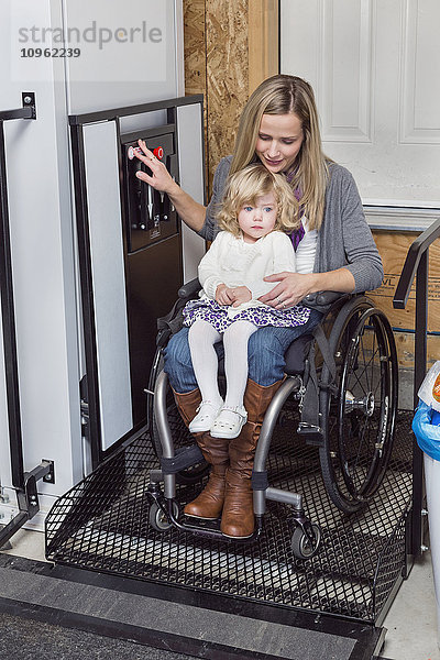 Junge behinderte Mutter mit ihrer Tochter  die einen Rollstuhl zur Unterstützung ihrer Mobilität benutzt; Spruce Grove  Alberta  Kanada'.