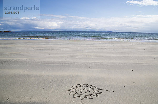 Blume mit fröhlichem Gesicht im Sand am Strand gezeichnet; Isle of Mull  Arygll and Bute  Schottland'.