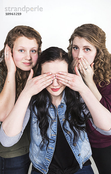 Drei junge Frauen in der humorvollen Pose von Hear no evil  see no evil  speak no evil; Alberta  Kanada