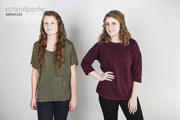 Studio-Porträt von zwei jungen Frauen vor weißem Hintergrund; Alberta  Kanada