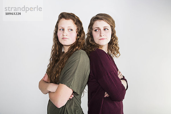 Studioaufnahme von zwei streitenden Freundinnen vor weißem Hintergrund; Alberta  Kanada'.