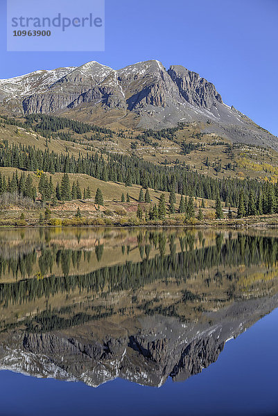 Landschaft mit zerklüfteten Bergen und Kiefernwäldern  die sich in einem ruhigen See spiegeln; Colorado  Vereinigte Staaten von Amerika'.