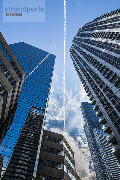 Kondensstreifen im blauen Himmel spiegeln sich auf den umliegenden Wolkenkratzern; Toronto  Ontario  Kanada'.
