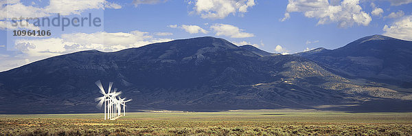 Einzelne Reihe von Windgeneratoren mit Bergen dahinter  in der Nähe von Milford; Utah  Vereinigte Staaten von Amerika'.