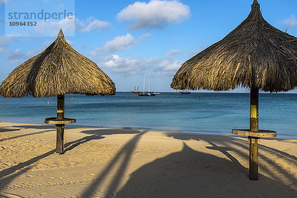 Strandpaläste am Palm Beach mit Segelbooten  die in Ufernähe ankern; Aruba'.