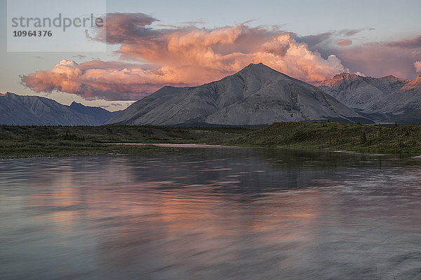 Die Mitternachtssonne scheint auf die Berge und Wolken  die den Wind River im Peel-Wassereinzugsgebiet säumen; Yukon  Kanada .