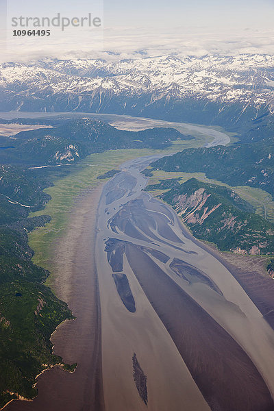 Luftaufnahme von schneebedeckten Gipfeln  die ein grünes Flusstal umgeben  Aleutian Range  Alaska-Halbinsel  Südwest-Alaska  USA  Sommer'
