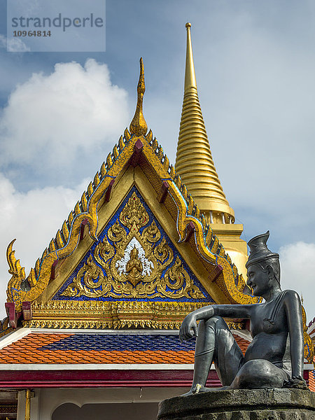 Ein verziertes und farbenfrohes Gebäude mit einer Statue mit menschlichem Abbild  Tempel des Smaragdbuddhas (Wat Phra Kaew); Bangkok  Thailand'.