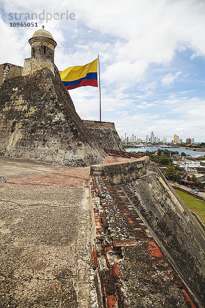 Castillo San Felipe de Barajas und kolumbianische Flagge mit Cartagena New City im Hintergrund; Cartagena  Kolumbien'.