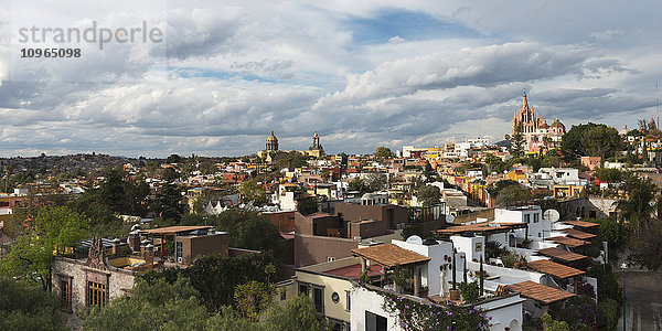 Stadtbild und Kirche in der Ferne unter bewölktem Himmel; San Miguel de Allende  Guanajuato  Mexiko'.