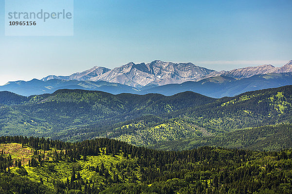 Aussichtspunkt auf ein hügeliges Vorgebirge mit einer Bergkette im Hintergrund und blauem Himmel; Kananaskis Country  Alberta  Kanada'.