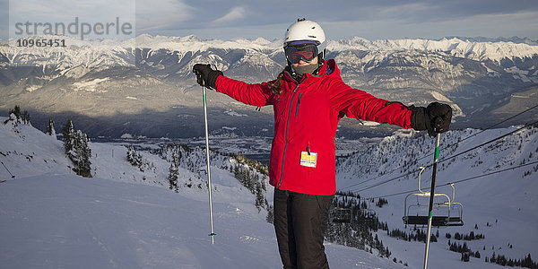 Ein Skifahrer auf einem Berggipfel mit Blick auf die kanadischen Rocky Mountains  Banff-Nationalpark; Alberta  Kanada