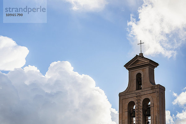 Kreuz und Glockenturm einer Kirche vor einem blauen Himmel mit Wolken; Rom  Italien