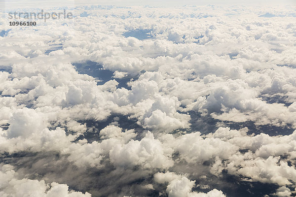 Luftaufnahme von verstreuten Wolken  schneebedeckte Gipfel erheben sich über die Wolken im Hintergrund; Alaska  Vereinigte Staaten von Amerika'.