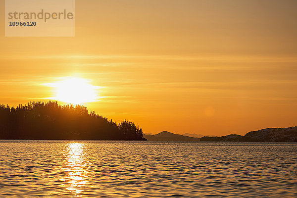 Die untergehende Sonne zeichnet die Silhouette der Waldkämme und Halbinseln im Prince William Sound; Whittier  Alaska  Vereinigte Staaten von Amerika'.