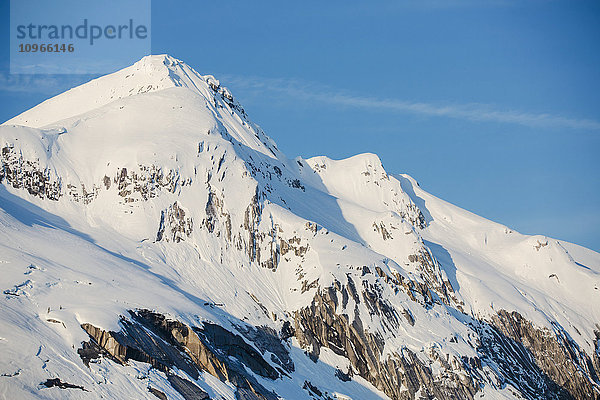 Schneebedeckte Felsen im Licht des Sonnenuntergangs am Ufer der Kings Bay  Prince William Sound; Whittier  Alaska  Vereinigte Staaten von Amerika'.