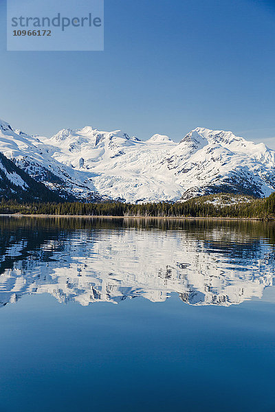 Ein Gletscher hängt in einem Tal unter zerklüfteten schneebedeckten Gipfeln in Kings Bay  Prince William Sound; Whittier  Alaska  Vereinigte Staaten von Amerika'.