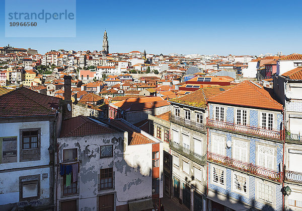 Dächer von Häusern und ein Turm in der Ferne vor blauem Himmel; Porto  Portugal