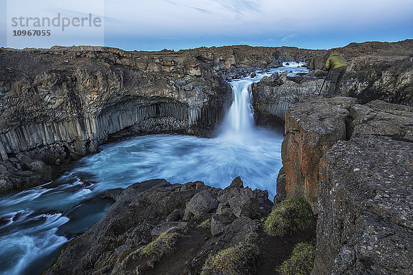 Die Basaltsäule und der Wasserfall Aldeyjarfoss in Nordisland  eine Person steht an der Spitze und fotografiert sie; Island'