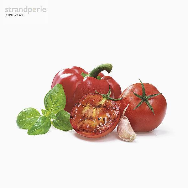 Gebratene Tomate mit Knoblauch  roter Paprika und Basilikumblättern auf weißem Hintergrund; Toronto  Ontario  Kanada'.