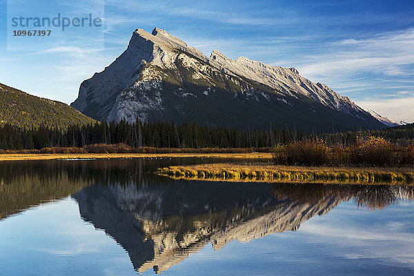 Bergsee  in dem sich der Berg bei Sonnenuntergang mit blauem Himmel und Wolken spiegelt  Banff National Park; Alberta  Kanada'.